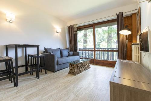- un salon avec un canapé et une table dans l'établissement Résidence du Brévent - Chamonix Village, à Chamonix-Mont-Blanc