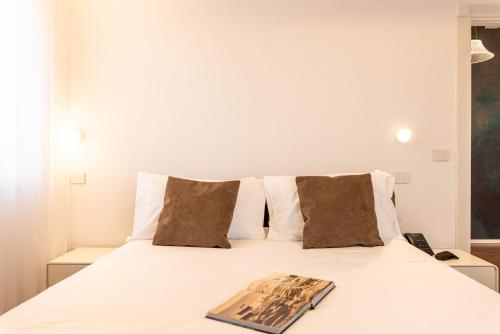 a bedroom with a white bed with a book on it at TENUTA FOGLIANI Resort & Natural Spa in Visciano