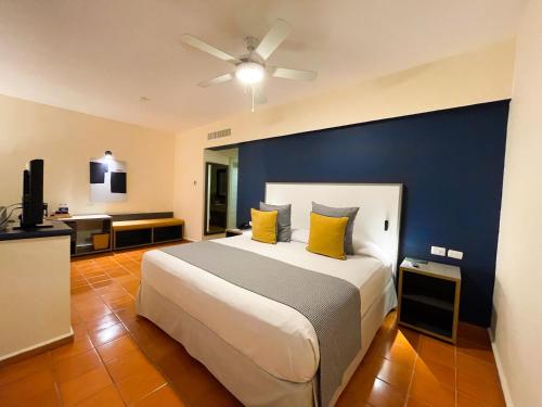 een slaapkamer met een groot bed met een blauwe muur bij Catalonia Punta Cana - All Inclusive in Punta Cana