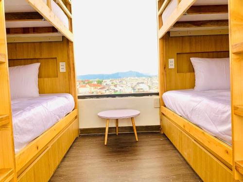 a small room with two bunk beds and a table at Torino Hotel Dalat in Da Lat