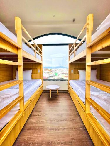 two bunk beds in a room with a window at Torino Hotel Dalat in Da Lat