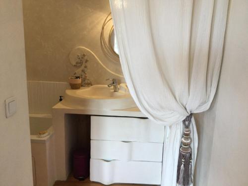 baño con lavabo y cortina de ducha en Maison cosy à la campagne en Montpeyroux