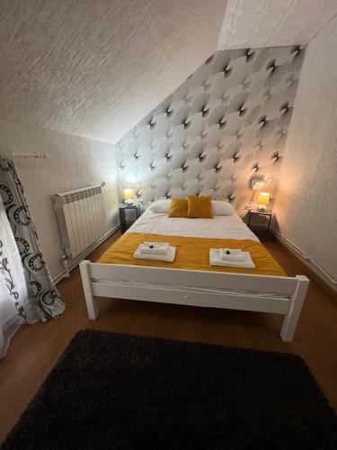a bedroom with a large bed with two towels on it at CASA ARIAN in Haţeg