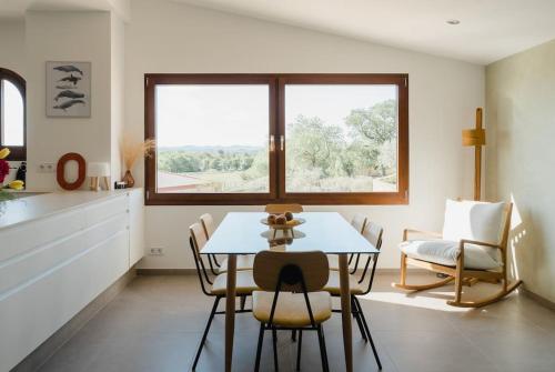 a dining room with a table and chairs and a window at La Pomera in Ultramort