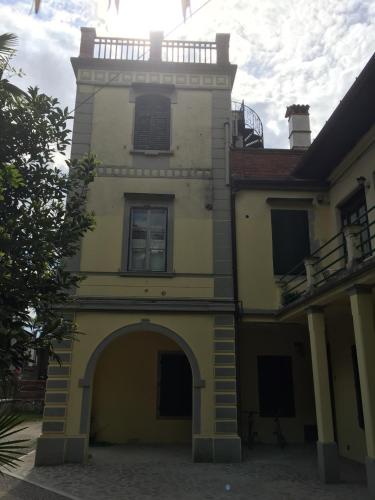 a yellow building with a tower with an archway at Villa Rosi in Cormòns