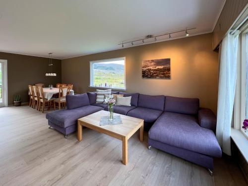 sala de estar con sofá púrpura y mesa en Midt i Lofoten, en Alstad