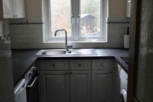 una cucina con lavandino e finestra di Ivy House a Bangor