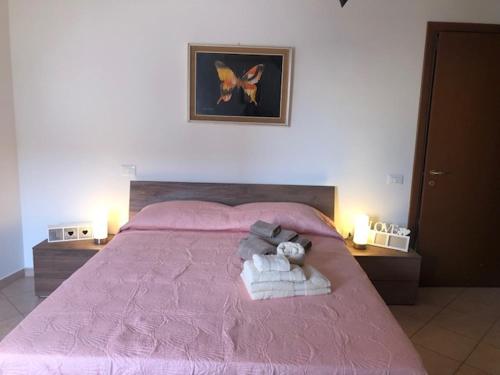a bedroom with a pink bed with a stuffed animal on it at Home Sulcitana in Elmas