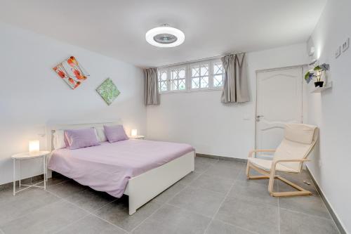 um quarto com uma cama, uma cadeira e uma janela em Neptuno 2A017 em Puerto de Santiago