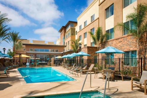 a pool at a hotel with chairs and umbrellas at Residence Inn by Marriott Tustin Orange County in Tustin