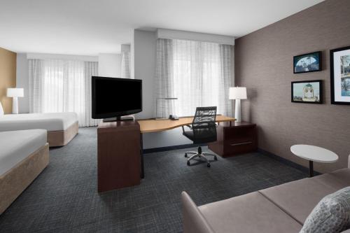 a hotel room with a bed and a desk with a television at Residence Inn by Marriott Tustin Orange County in Tustin