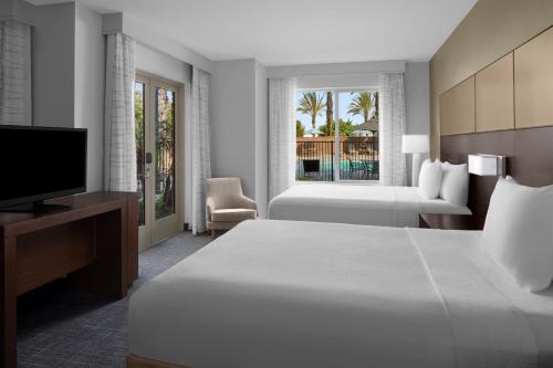 Habitación de hotel con cama y TV en Residence Inn by Marriott Tustin Orange County en Tustin