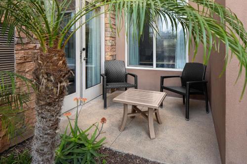 a patio with chairs and a table and a palm tree at Residence Inn by Marriott Tustin Orange County in Tustin