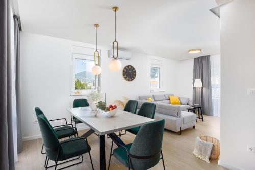 sala de estar con mesa y sillas verdes en Penthouse Apartments East and West Star, en Kaštela