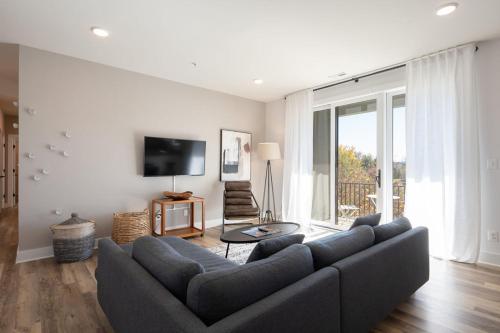 a living room with a couch and a tv at Piedmont Place Suite 402 Modern Apartment in Heart of Crozet in Crozet