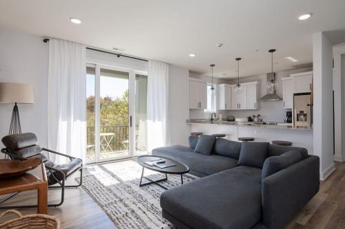 a living room with a blue couch and a kitchen at Piedmont Place Suite 402 Modern Apartment in Heart of Crozet in Crozet