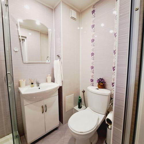 a white bathroom with a toilet and a sink at Apartment RELAX in the city center, free parking in Yambol