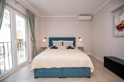 ザダルにあるLuxury room Ercegの白いベッドルーム(青いベッド1台、大きな窓付)