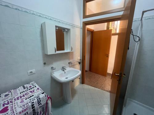 un baño con lavabo y espejo en Caccia Apartment, en Santa Teresa di Riva
