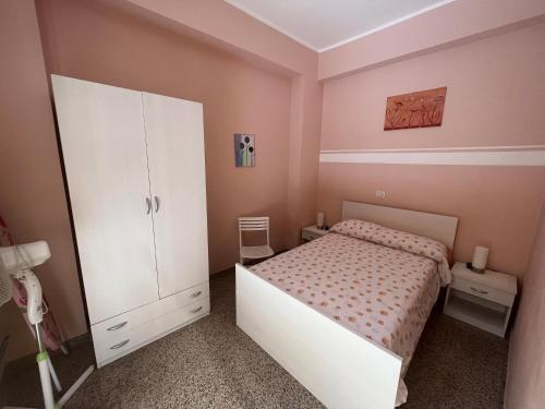 1 dormitorio con 1 cama y armario blanco en Caccia Apartment, en Santa Teresa di Riva