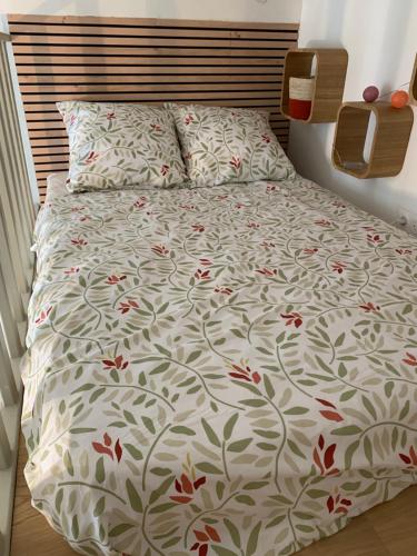 une chambre avec un lit avec des fleurs rouges dessus dans l'établissement STUDIO PARIS ODEON, à Paris