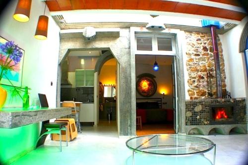 a living room with a stone fireplace and a glass table at zentral club electrón- jacuzzi. in Belmonte de Miranda