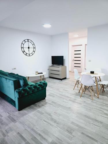 a living room with a couch and tables and a clock at Comapart in Bacău