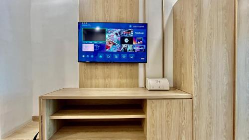 a tv sitting on top of a wooden cabinet at Hotel Limon & Banquet Sector 29, Gurgaon in Gurgaon