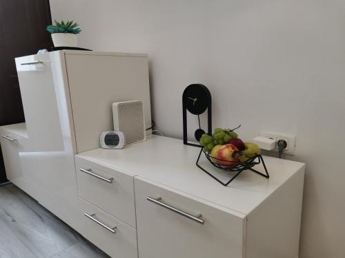 a white cabinet with a bowl of fruit on it at Iris's apartament in Sinaia