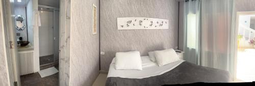 a small bedroom with a bed with white pillows at Le Castel Blanc Hotel Boutique in San Andrés