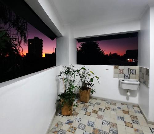 a bathroom with a toilet and a sink and two windows at Las Arecas 2° B - Perito Moreno in Puerto Iguazú