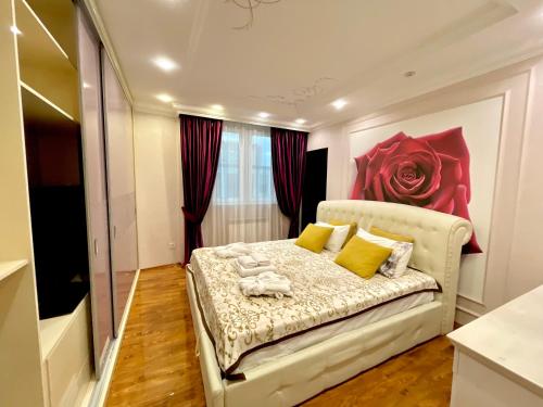 a bedroom with a bed with a flower on the wall at Kuat house in Almaty