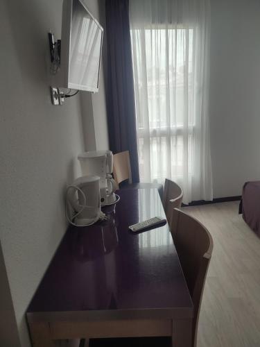 - une table avec une cafetière et une télécommande dans l'établissement Résidence la closeraie, à Lourdes