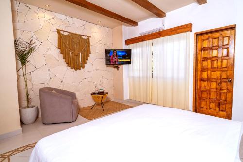 1 dormitorio con 1 cama y TV en la pared en Enigmatic Hotel Experience en Cancún