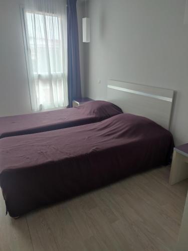 une chambre avec un grand lit avec une fenêtre dans l'établissement Résidence la closeraie, à Lourdes