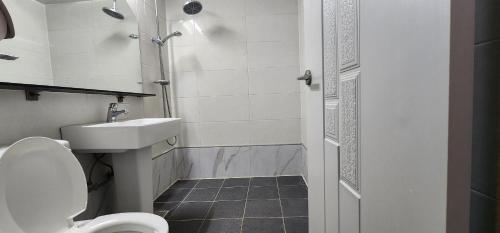 a bathroom with a toilet and a sink and a shower at Namhae Beach Hotel in Namhae