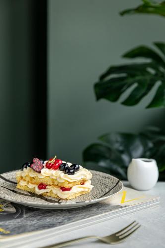 a cake with berries on a plate on a table at Mercure Milano Agrate Brianza in Agrate Brianza