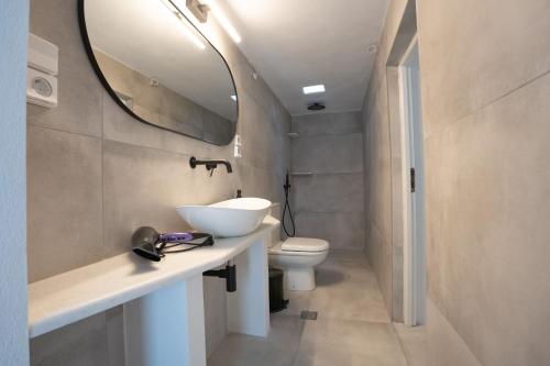 a bathroom with a sink and a toilet and a mirror at Traditional White House in Prodromos Paros