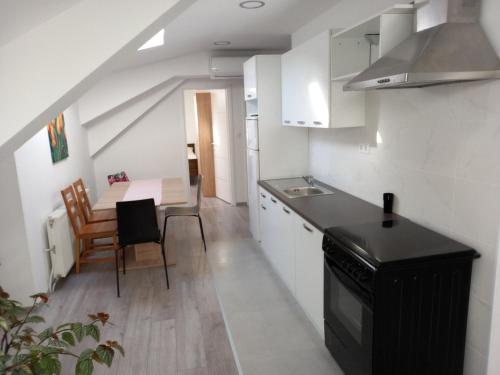 uma pequena cozinha e sala de jantar com mesa em Apartmani Dubrava 2 em Zagreb