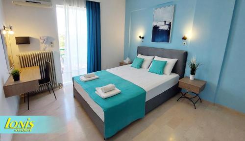 1 dormitorio con 1 cama grande y paredes azules en Ionis Studios en Lefkada