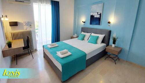 a bedroom with a large bed with blue walls at Ionis Studios in Lefkada