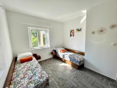 a small room with two beds and a window at Apartman Mirna in Betina