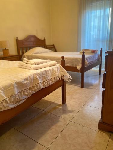 a bedroom with two beds and a window at Apartamento Varanda do Sol in Amora