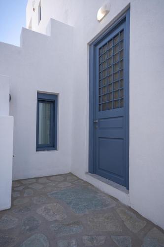 a blue door on the side of a white building at Traditional White House in Prodromos Paros