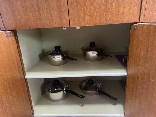 a cabinet with three pots sitting on shelves at One Bedroom Main floor Apartment in Camrose