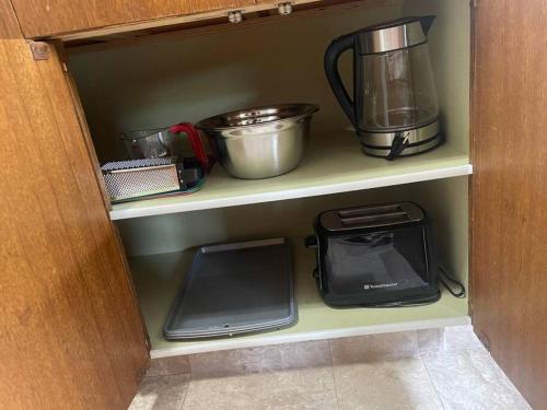 a cupboard with various kitchen utensils and appliances at One Bedroom Main floor Apartment in Camrose