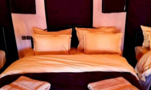 a bedroom with a large bed with orange pillows at Your journey starts here in Merzouga