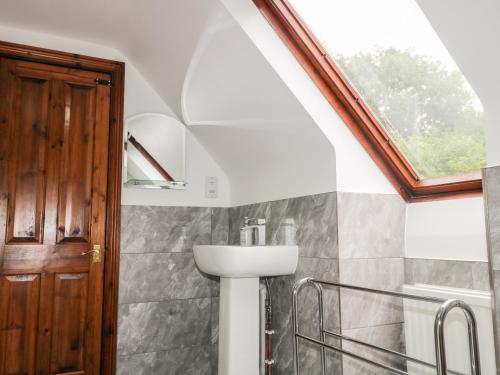 a bathroom with a sink and a window at Miswells Cottages - Lake View in Turners Hill