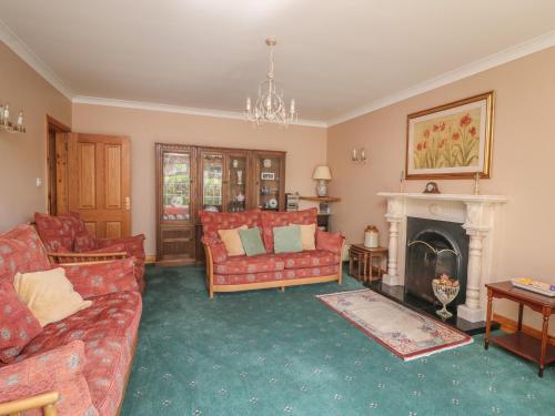 a living room with red couches and a fireplace at Bolger House in Blackwater