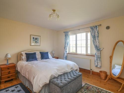 a bedroom with a bed and a window and a chair at Bolger House in Blackwater